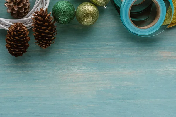 Vista superior de conos de pino y decoraciones para la corona de Navidad hecha a mano en la superficie de madera azul - foto de stock