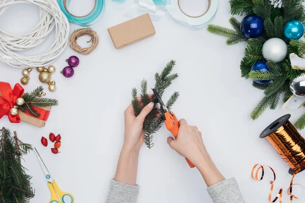 Vue partielle de la femme coupe branche de pin pour la décoration de Noël isolé sur blanc — Photo de stock
