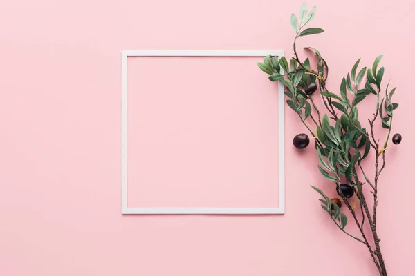 Flat lay with frame and branch with decorated berries on pink — Stock Photo