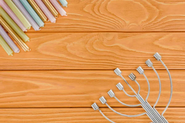 Vue de dessus de menorah juive traditionnelle et bougies colorées sur table en bois, concept de vacances hannukah — Photo de stock
