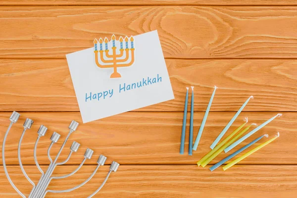 Flat lay with happy hannukah card, candles and menorah on wooden surface, hannukah concept — Stock Photo
