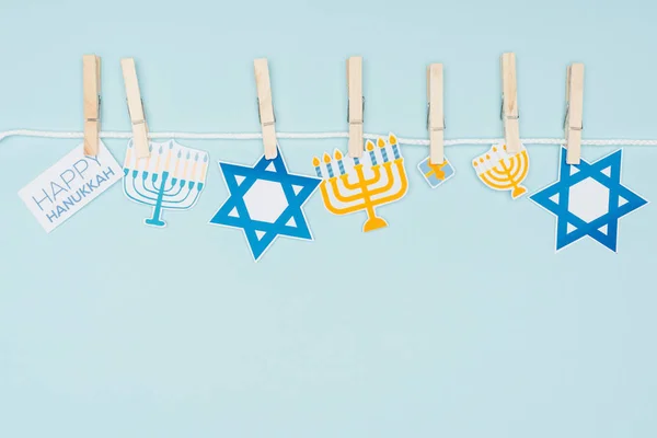 Vista superior de carteles de papel de vacaciones hannukah fijados en la cuerda aislada en azul, concepto hannukah - foto de stock