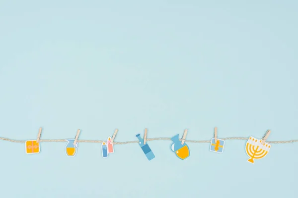 Vue du dessus des panneaux de papier de vacances hannukah accrochés à une corde isolée sur bleu, concept hannukah — Photo de stock