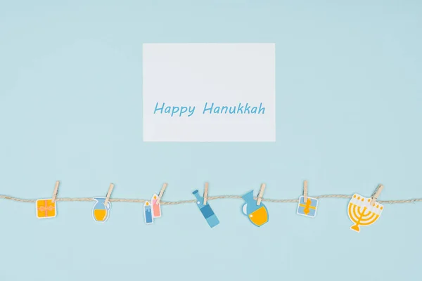 Top view of happy hannukah card and holiday paper signs pegged on rope isolated on blue, hannukah concept — Stock Photo