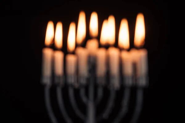 Imagen desenfocada de la menorá judía con velas para la celebración de vacaciones hannukah aislado en negro, concepto hannukah - foto de stock