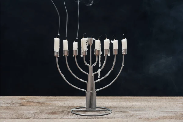 Vista da vicino della menorah con candele per la celebrazione delle vacanze hannukah su una superficie di legno isolata su nero, concetto di hannukah — Foto stock