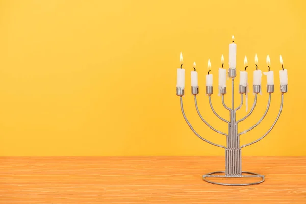 Vista de perto de menorah com velas para celebração de férias de hannukah em mesa de madeira isolada em amarelo, conceito de hannukah — Fotografia de Stock