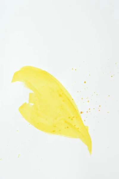Trait d'aquarelle abstrait jaune avec éclaboussures sur papier blanc — Photo de stock
