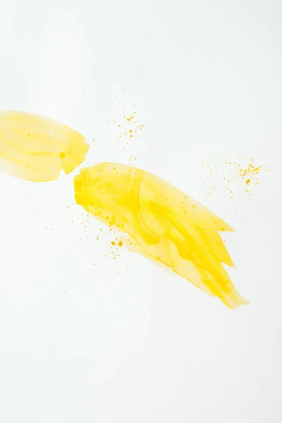 Abstract yellow watercolor strokes with splatters on white paper background — Stock Photo