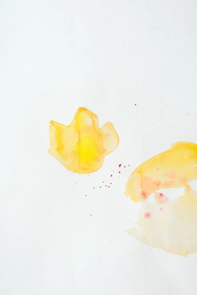 Traços de aquarela laranja e amarelo no fundo do papel branco — Fotografia de Stock