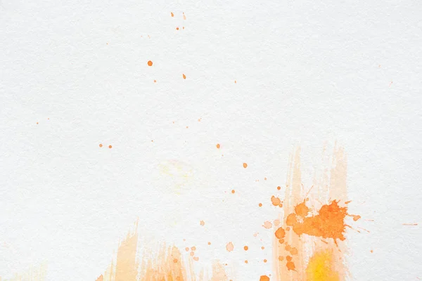 Pintura aquarela laranja com salpicos em papel branco — Fotografia de Stock