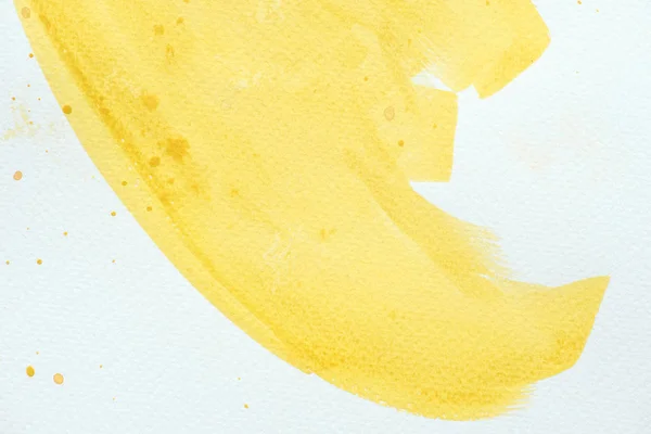 Primer plano del trazo de acuarela amarilla sobre fondo de papel blanco - foto de stock