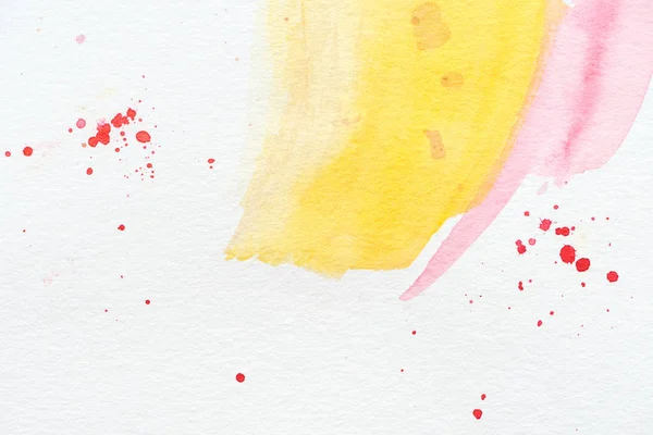 Fundo abstrato com traços de aguarela amarelo e rosa com respingos vermelhos — Fotografia de Stock