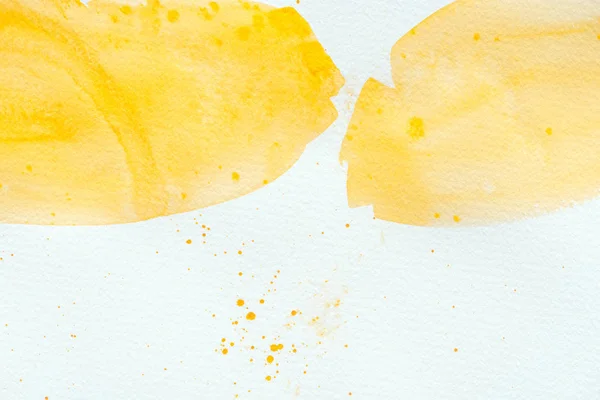 Trazos abstractos de acuarela amarilla sobre papel blanco - foto de stock