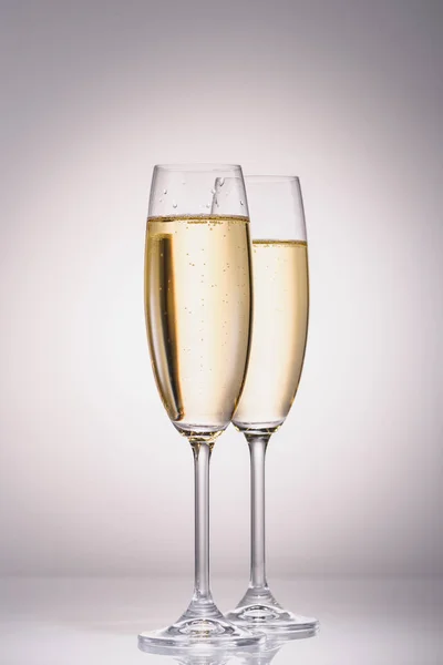 Close up view of glasses of champagne on grey backdrop — Stock Photo