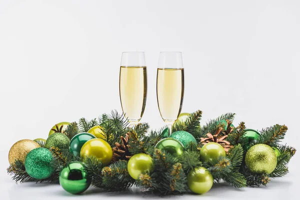 Vista da vicino del bicchiere di champagne e festiva corona di Natale su sfondo bianco — Foto stock