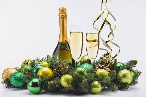 Close up view of bottle and glasses of champagne with christmas wreath on white background — Stock Photo