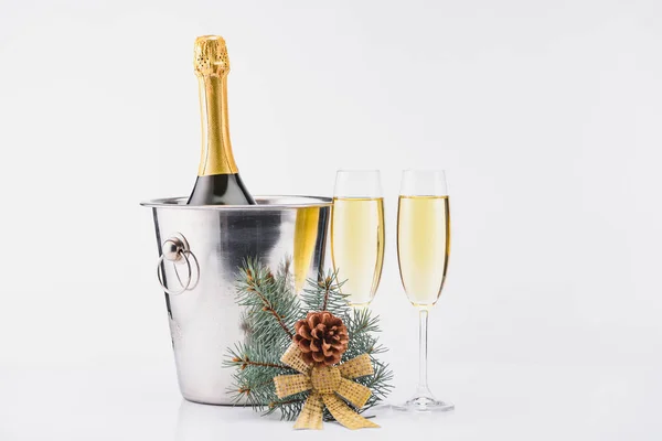 Vue rapprochée de la bouteille de champagne dans un seau et des verres de champagne sur fond gris — Photo de stock