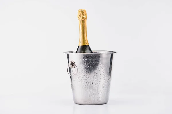 Close up view of bottle of champagne in bucket on grey backdrop — Stock Photo