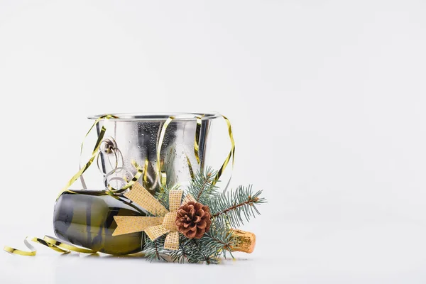 Close up view of bottle of champagne with christmas decoration lying near bucket on grey background — Stock Photo