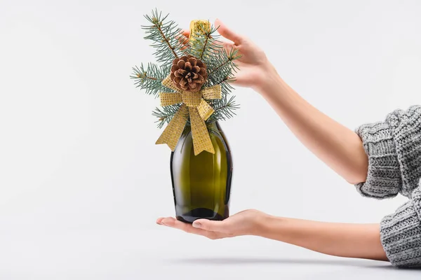 Tiro recortado de mulher segurando garrafa decorada de champanhe em mãos em pano de fundo branco, ano novo e conceito de celebração de Natal — Fotografia de Stock