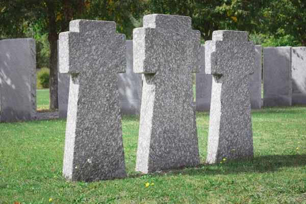 Fuoco selettivo di croci di pietra commemorative poste in fila a cimitero — Foto stock