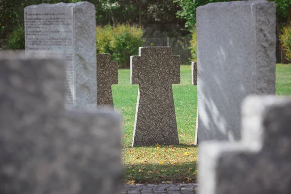 Foco seletivo de cruzes de pedra comemorativas colocadas em linha no cemitério — Fotografia de Stock