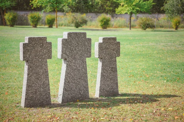 Selektiver Schwerpunkt der Gedenksteinkreuze, die in Reih und Glied auf Gras auf dem Friedhof aufgestellt wurden — Stockfoto