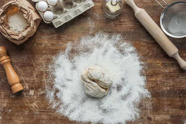 Top view of raw dough with baking ingredients on wooden table — Stock Photo