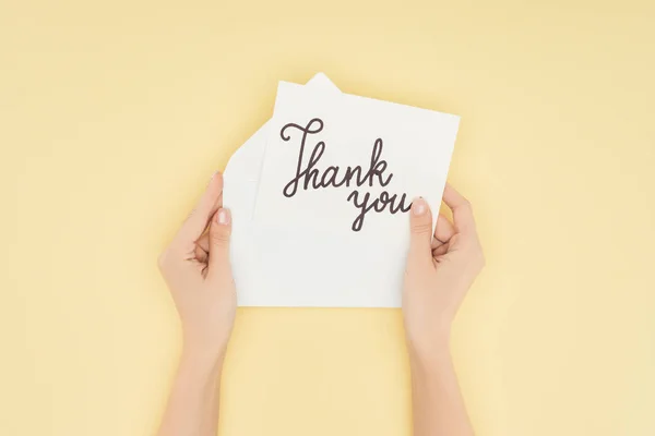 Cropped person holding paper with thank you lettering isolated on yellow background — Stock Photo
