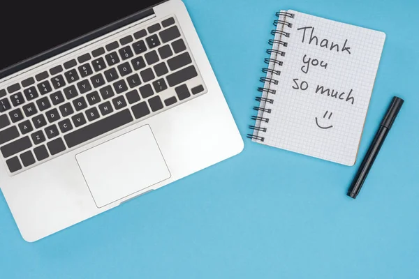 Laptop, Stift und Notizbuch mit vielen Schriftzügen auf blauem Hintergrund — Stockfoto