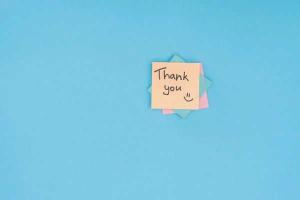 Colorful sticky notes with thank you lettering isolated on blue background — Stock Photo