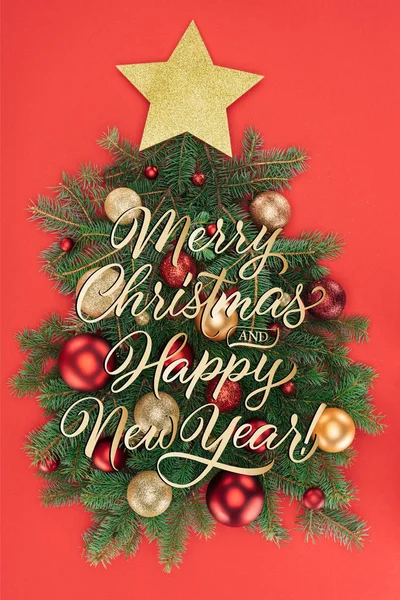 Ansicht von Tannenzweigen, goldenem Stern und Weihnachtskugeln in Weihnachtsbaum isoliert auf Rot mit dem Schriftzug 