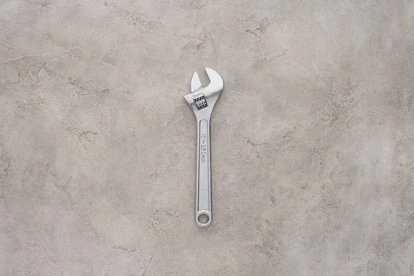 Top view of adjustable pipe wrench lying on concrete surface — Stock Photo