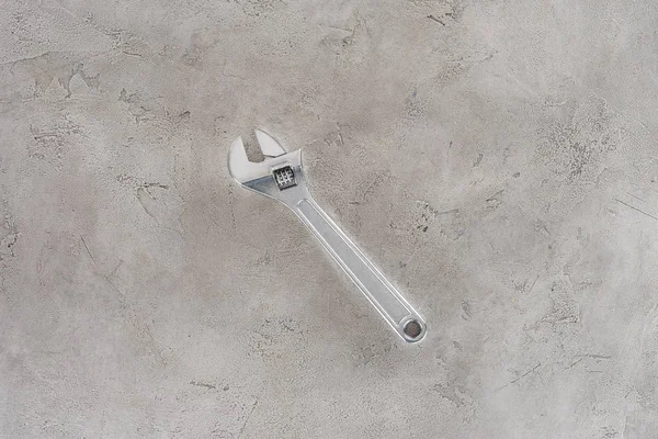 Top view of pipe wrench lying on concrete surface — Stock Photo