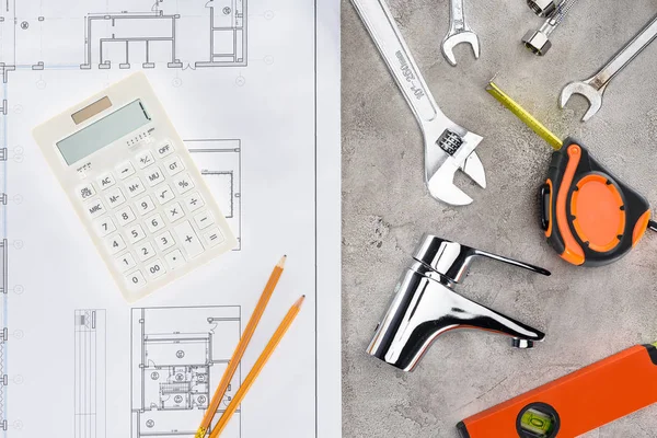 Vue de dessus du plan de construction avec divers outils et calculatrice sur la surface du béton — Photo de stock