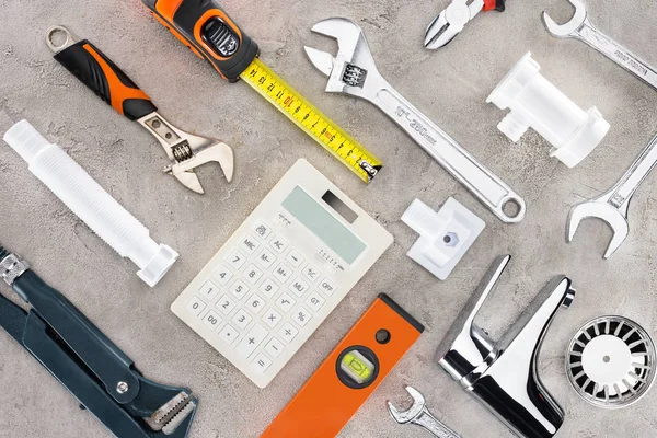 Flache Verlegung mit verschiedenen Werkzeugen und Taschenrechner auf Betonoberfläche — Stockfoto