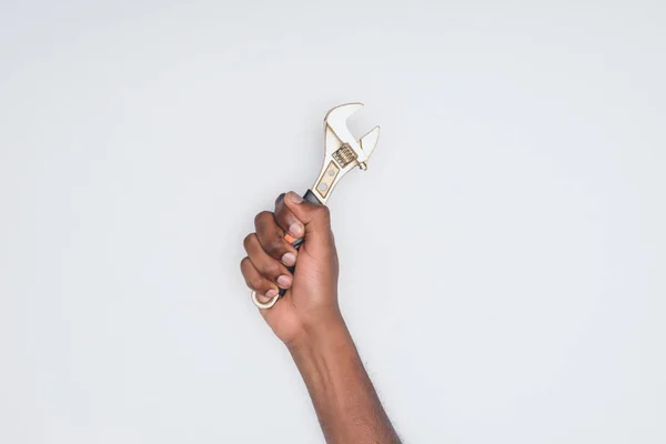 Cropped shot of african american man holding wrench isolated on white — Stock Photo
