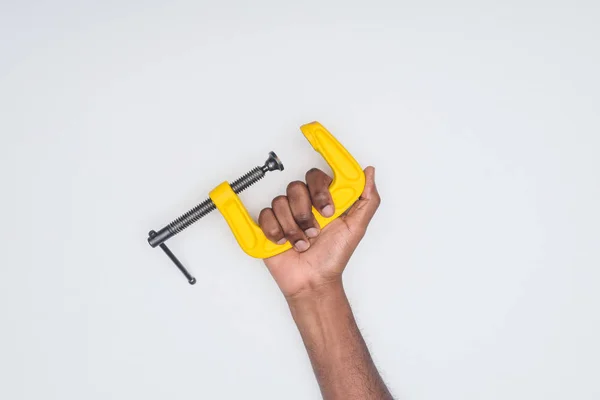 Cropped shot of african american man holding vise tool isolated on white — Stock Photo