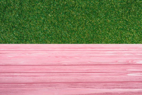 Vorlage aus rosa Holzboden mit grünem Gras auf Hintergrund — Stockfoto