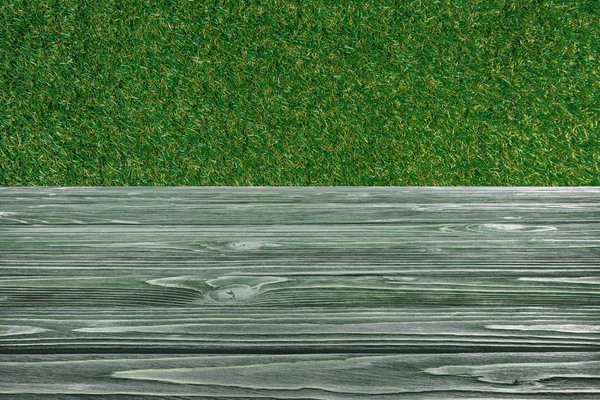 Template of dark green wooden floor with green grass on background — Stock Photo