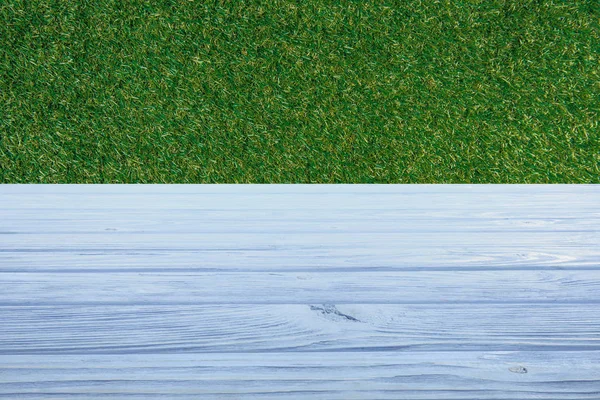Plantilla de piso de madera azul claro con hierba verde en el fondo - foto de stock