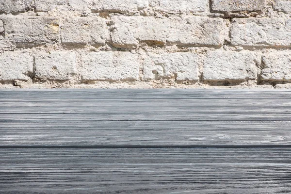 Template of grey wooden floor with white brick wall on background — Stock Photo