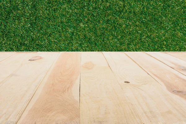Template of beige wooden floor made of planks on green grass background — Stock Photo