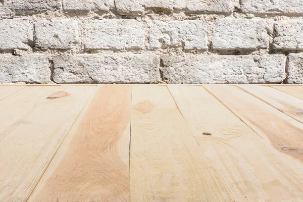 Template of beige wooden floor made of planks with brick wall on background — Stock Photo