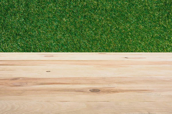 Gabarit de plancher en bois beige avec herbe verte sur le fond — Photo de stock