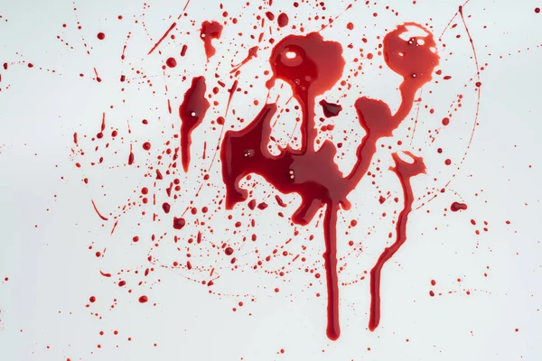 Close-up shot of messy blood splashes on white tabletop — Stock Photo