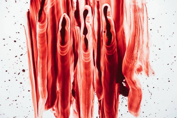 Vista superior de manchas de sangre untadas con la mano sobre la superficie blanca — Stock Photo