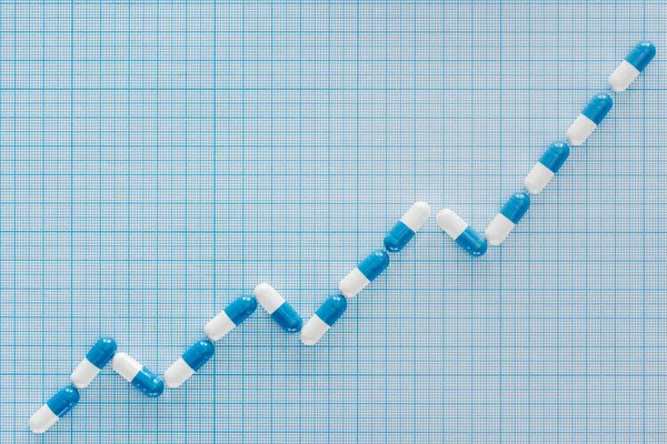 Flat lay with pills graph on blue checkered surface — Stock Photo