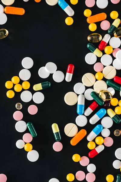 Vista da di mucchio colorato varie pillole isolate sul nero — Foto stock